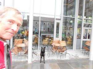 Filmcamera opladen in café naast kathedraal, terwijl Tosca buiten de wacht houdt
