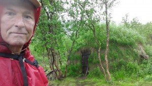 Traditionele samen hut met wilderness man ervoor